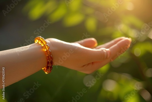 A woman's hand wearing an amber bracelet. Amber stone jewelry