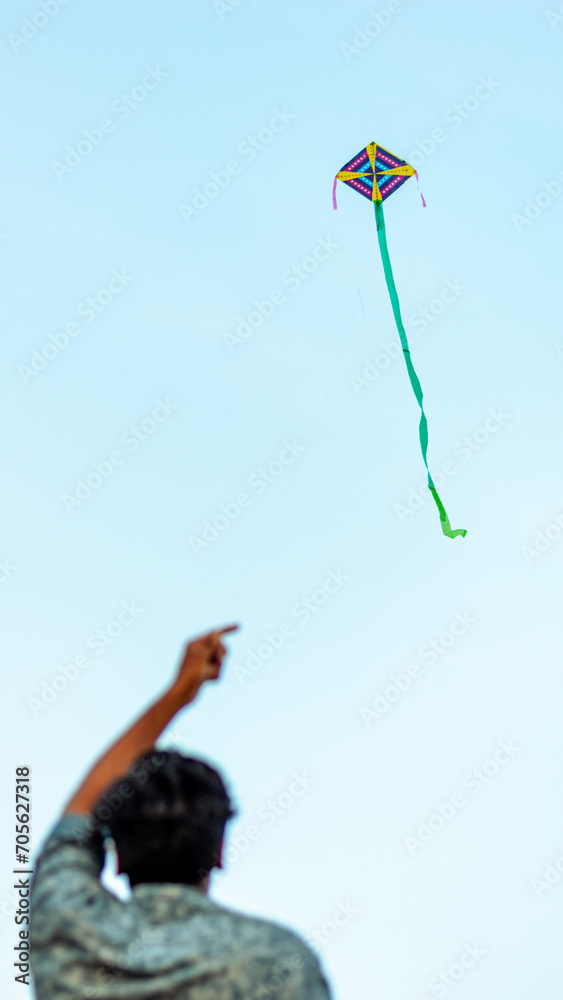 A picture of a guy flying a kite