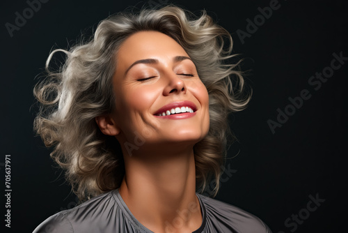 Woman with her eyes closed and her hair blowing in the wind.