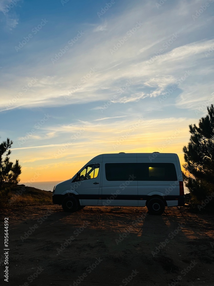 Van parked at the ocean coast, sunset time at the ocean bay