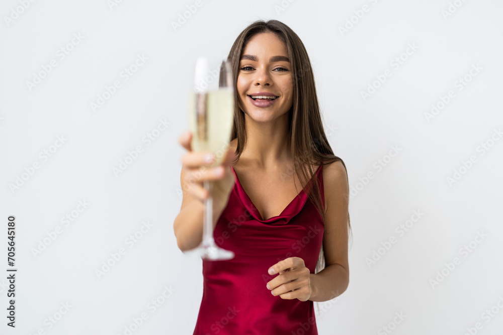 Young celebrating woman in red dress . Beautiful model portrait isolated over white background hold wine glass. Young celebrating woman in red dress . Beautiful model portrait isolated over white background hold wine glass.