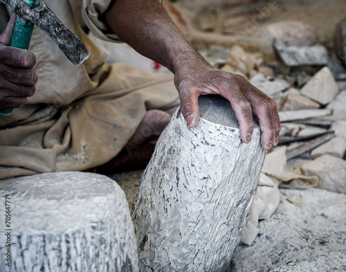 hands of a male Egyptian sculptor while working with a stone alabaster