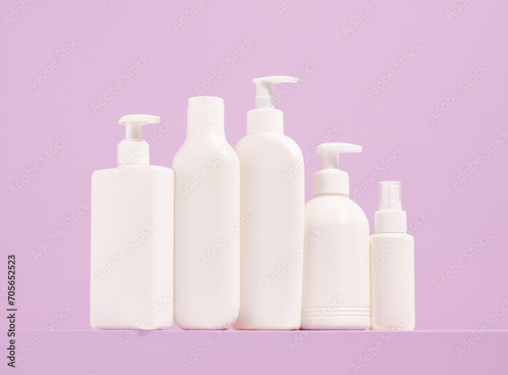 White dispensers with various shower gels and shampoos stand in a row. Cosmetic cleaning and care products. White dispensers with various shower gels and shampoos stand in a row. Cosmetic cleaning and care products.