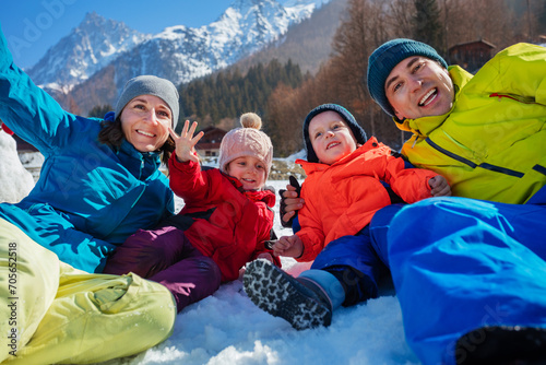 Cheerful family portrait on winter holiday in sunny mountains
