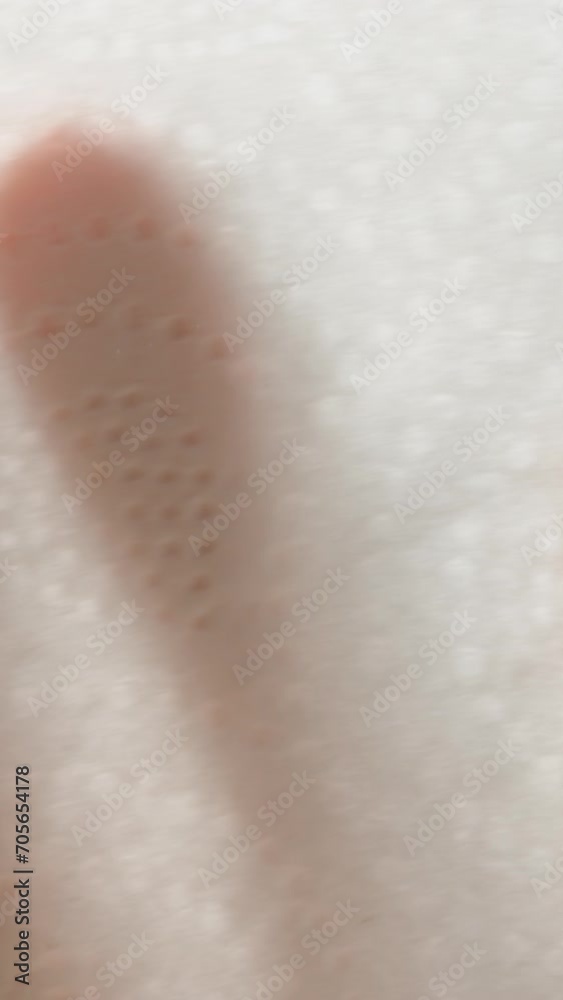 Vertical video. I wipe the glass with a napkin on a blue background. View from the reverse side, close-up. Vertical video. I wipe the glass with a napkin on a blue background. View from the reverse side, close-up.