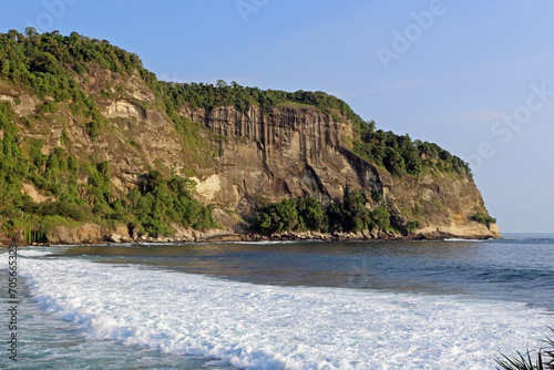 View of the idyllic Indonesian coast of Java Island with majestic mountains and tranquil ocean waters.