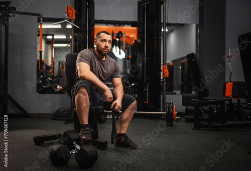 A large bearded man in the gym performs a squat exercise with a barbell. Preparation of a weightlifter for competitions Natural weight gain without the use of steroids.