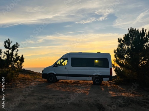 Van parked at the ocean coast, sunset time at the ocean bay