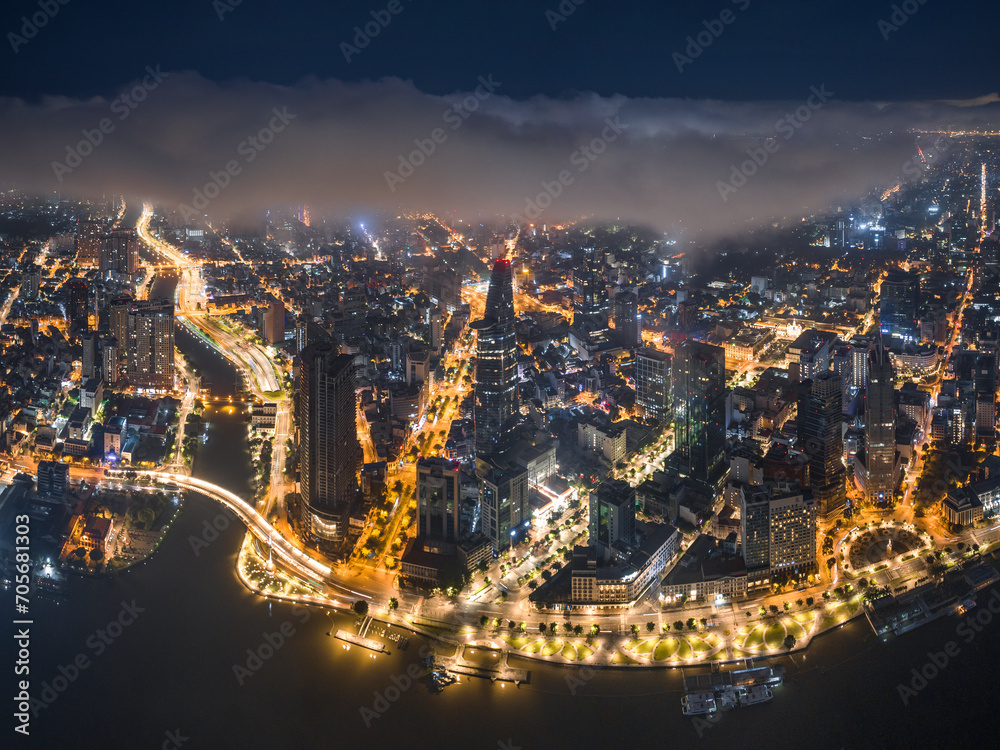 Naklejka premium Aerial photo of downtown Ho Chi Minh City, Vietnam's largest city with high-rise buildings next to the riverbank.