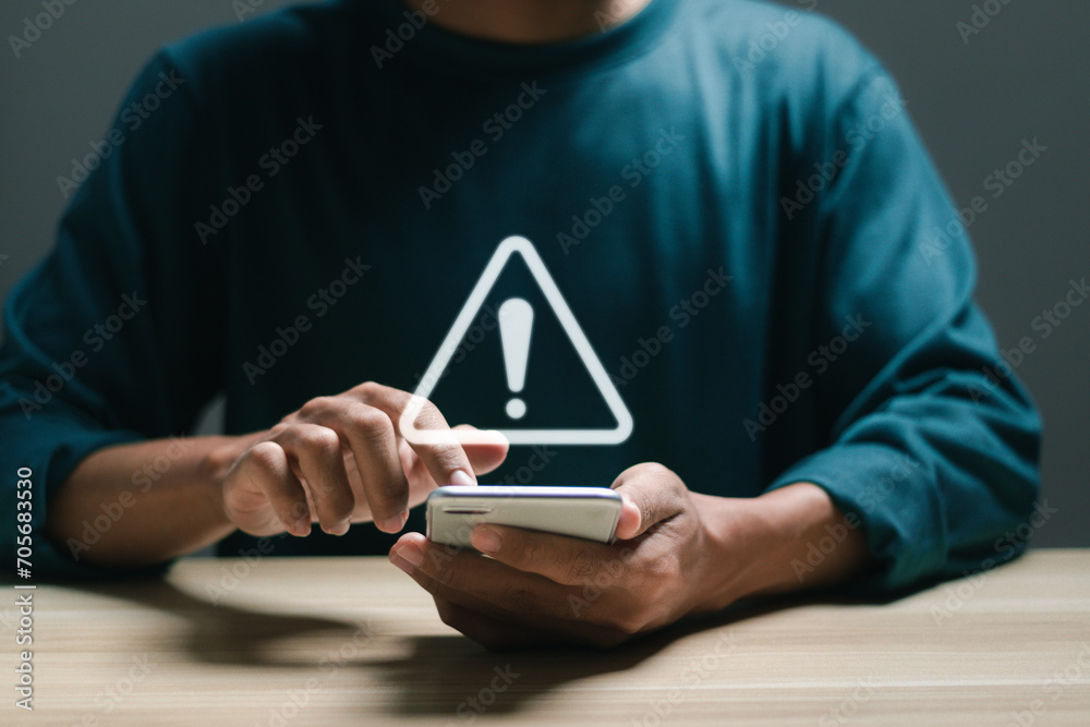 Businessman use mobile smart phone with virtual warning sign for caution in investing economic situation warning, Business investment risks. - obrazy, fototapety, plakaty 