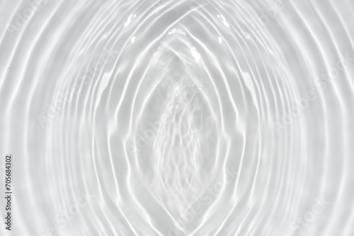 White water with ripples on the surface. Defocus blurred transparent white colored clear calm water surface texture with splashes and bubbles. Water waves with shining pattern texture background.