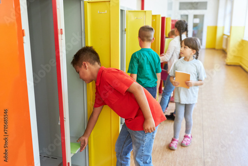 Boy keeping book in locker at school
