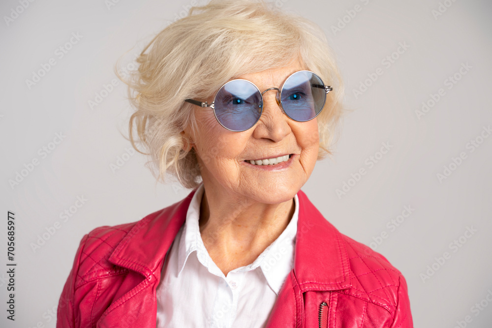Stylish senior smiling caucasian woman wearing glasses looking away Stylish senior smiling caucasian woman wearing glasses looking away