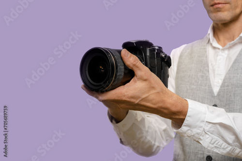 Young man using modern digital camera to earn money