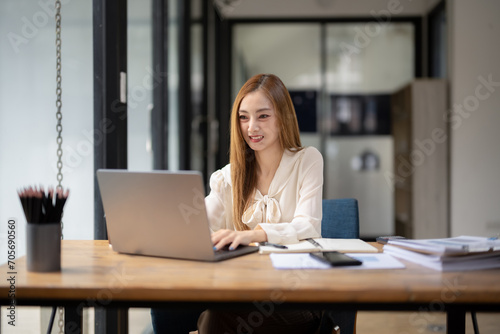 Business woman sitting and working using laptop, searching and checking information