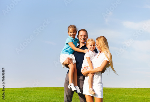 Happy young family with two children outdoors