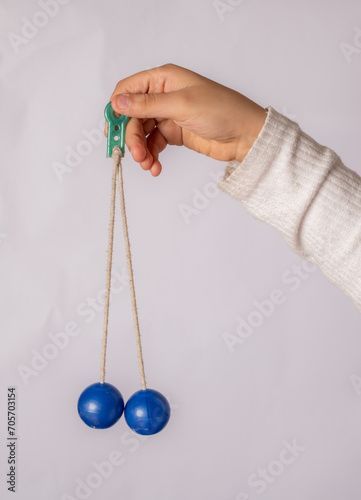 photo of clackers balls hanging by the hand  photo