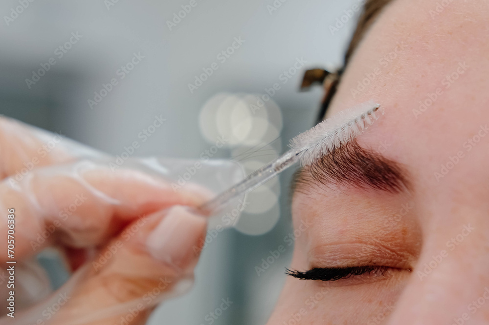 Makeup artist combs and plucks eyebrows after dyeing in a beauty salon.Professional makeup and cosmetology skin care. Makeup artist combs and plucks eyebrows after dyeing in a beauty salon.Professional makeup and cosmetology skin care.