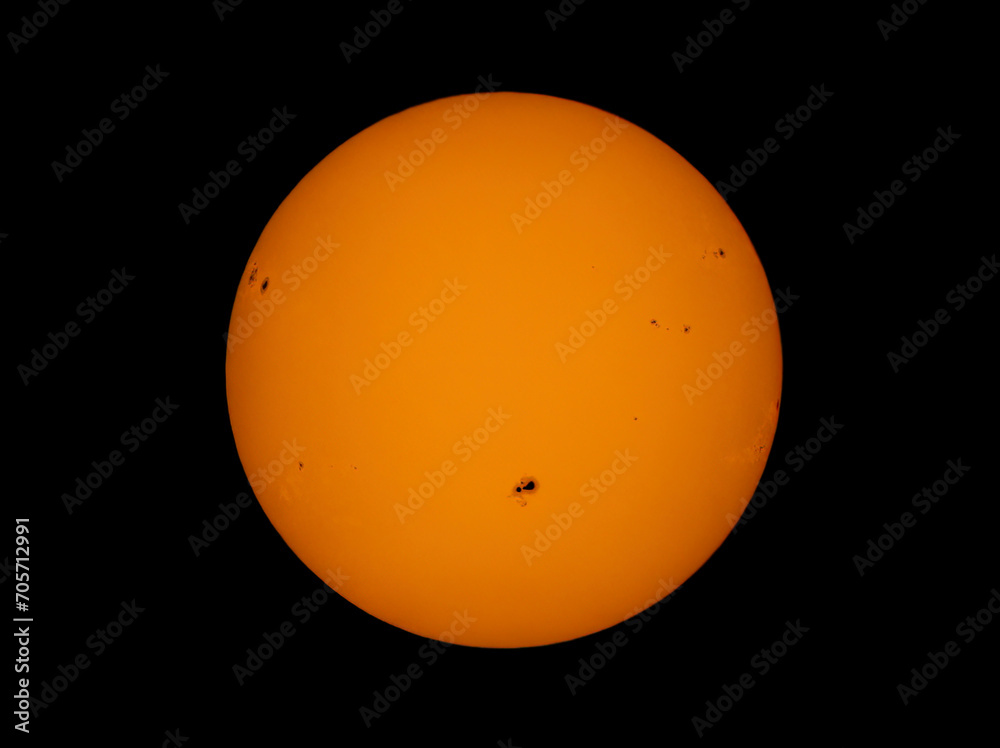 Sunspots on the sun using a homemade solar filter against a black background.