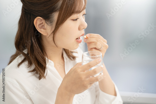 薬を飲む女性