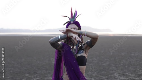 Young woman in traditional Indian clothes with jewelry dancing South Asian folk dance in nature. 