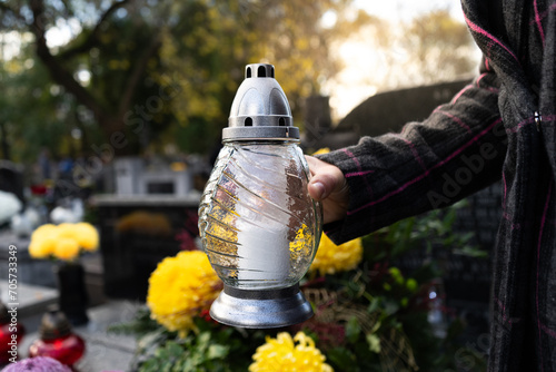 Fényképezés Woman holding cemetery grave candle glass lantern