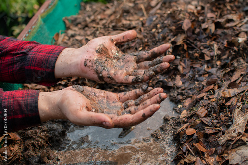 Farmer's hands covered in mud. Top view. Space for text.