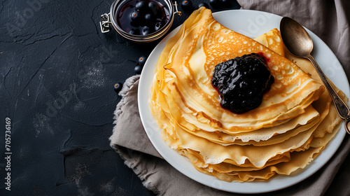 Pancakes stacked on white ceramic plate with honey and blueberry. Tasty breakfast, lunch or snack. Top view, close up photo