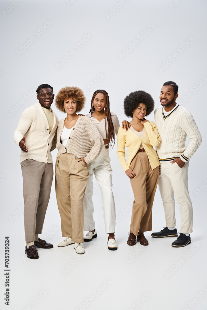 Obraz premium group of young african american men and women posing with hands in pockets on grey background