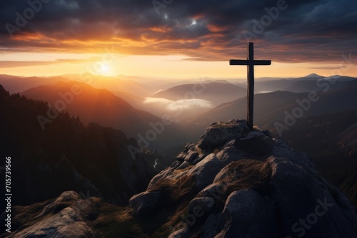  a cross on top of a mountain with the sun setting in the background and clouds in the sky over a valley with mountains and a mountain range in the foreground. © Nadia