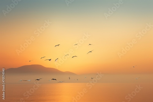  a flock of birds flying over a body of water with a mountain in the distance in the distance in the distance is a body of water with birds flying in the foreground. © Nadia