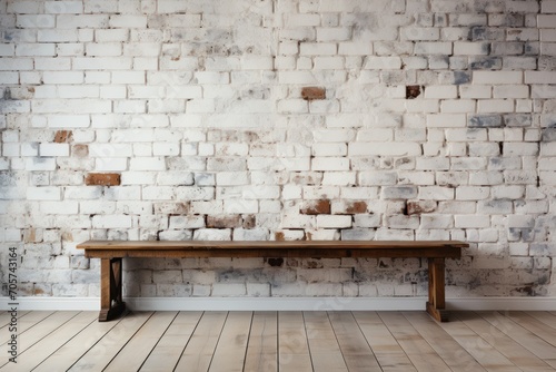  a wooden bench against a brick wall in a room with hard wood flooring and a white painted brick wall with a wooden bench in the middle of the floor. photo