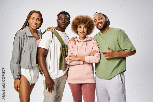 happy african american men and women smiling together on grey background, Juneteenth concept