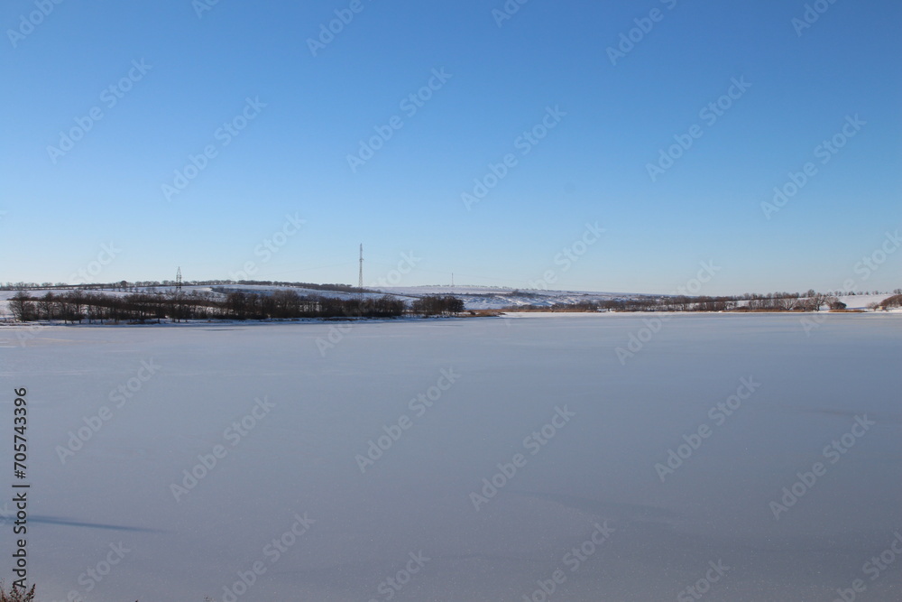 A snowy field with a city in the distance
