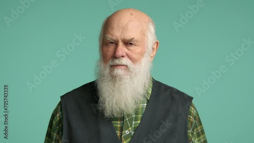 Elderly man with a large light beard, shaking his head no. He indicates disagreement and disapproval. His expression is stern. The man is dressed in a floral shirt with a grey vest. RED 8K RAW. photo