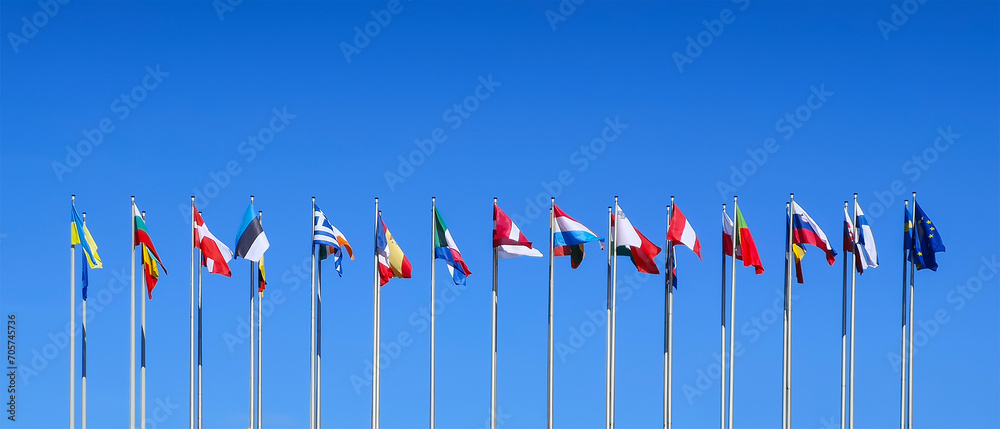 Poles with flags of the countries members of the European Union on blue sky background at the European Parliament in Strasbourg, Europe web banner