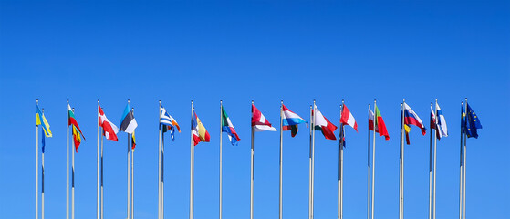 Poles with flags of the countries members of the European Union on blue sky background at the European Parliament in Strasbourg, Europe web banner