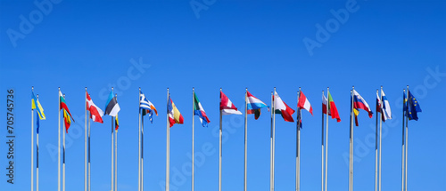 Poles with flags of the countries members of the European Union on blue sky background at the European Parliament in Strasbourg, Europe web banner