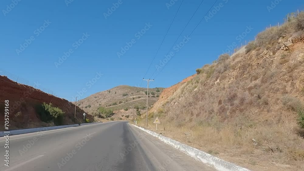 Driving in a deserted nature Crete Greece during a sunny day in summer on a desert road. View from a car windows along a country road. Riding a car with nature around. Driving in a deserted nature Crete Greece during a sunny day in summer on a desert road. View from a car windows along a country road. Riding a car with nature around.