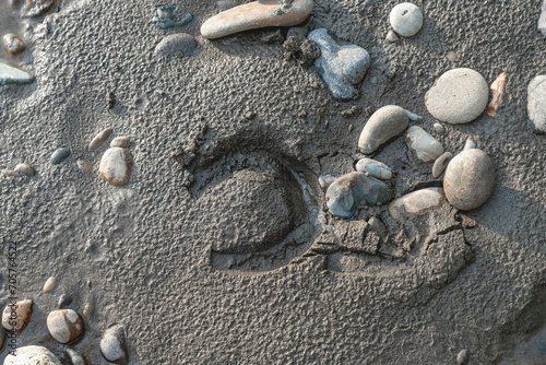Horse shoe foot hoof mark print at the sand in the beach near stones and pebbles
