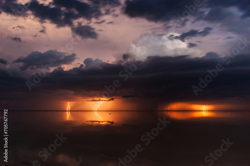 Thunderous dark sky. Black clouds and thunderstorm lightning.Concept on the theme stormy  thunderbolt  thunder  rain. Dramatic skies over the water landscape. Nature background.  