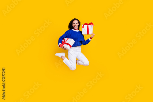 Full body length photo funky jumping woman prepared gift boxes for birthday party her best friend isolated on yellow color background