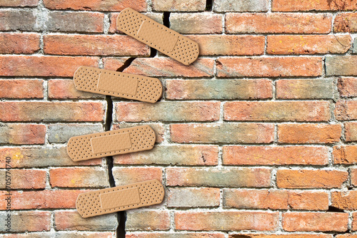 Renovation of an old cracked brick wall - concept with bandaid patch photo