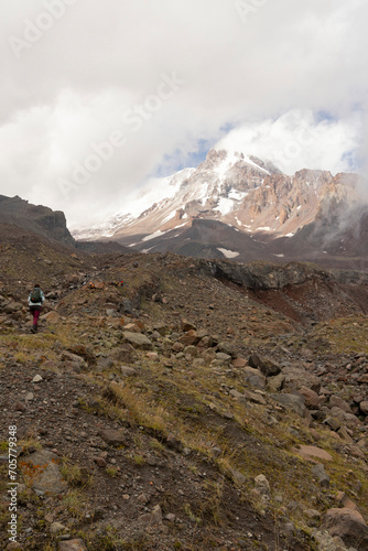 Tourist woman hiking in Georgia on Kazbek moutain in Caucasus moutains peak