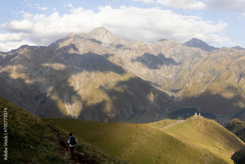 Tourist woman hiking in Georgia on Kazbek moutain in Caucasus moutains peak