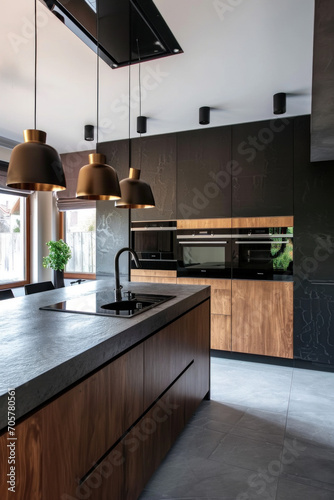 cuisine aménagée moderne composée de bois naturel et béton avec des éclairage suspendu de type spot photo