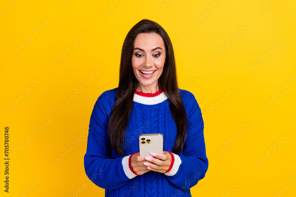 Portrait photo of young latin woman wear blue knit jumper using smartphone surprised bank balance ad isolated on yellow color background Portrait photo of young latin woman wear blue knit jumper using smartphone surprised bank balance ad isolated on yellow color background
