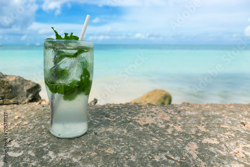 Travel background with drinks glass and straw on Caribbean beach.