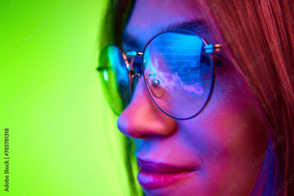 Focused developer, woman wears glasses working on computer looking at programming code which reflecting in glasses. Concept of trading, financial growth, technology, cyber security. Ad Focused developer, woman wears glasses working on computer looking at programming code which reflecting in glasses. Concept of trading, financial growth, technology, cyber security. Ad