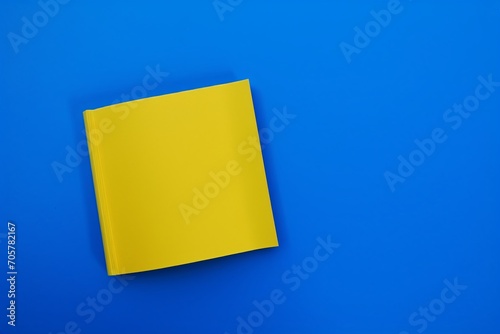 Blank yellow book on blue background. Top view with empty space.